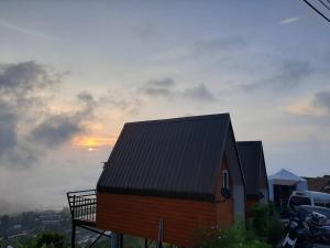 a small house with a black roof on a hill at Ing Ai Mhok Phu Thap Buek in Ban Tha Kok Hai