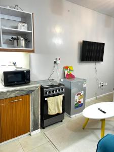 a kitchen with a stove and a microwave at Tsavo Coral Bells in Kiambu