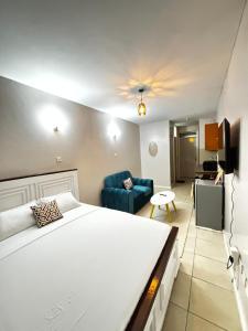 a bedroom with a large bed and a living room at Tsavo Coral Bells in Kiambu