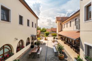 an alleyway between two buildings with tables and chairs at Penzion Onyx in Lednice