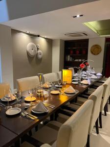a long wooden table with chairs and wine glasses at Kenton Palace Buenos Aires in Buenos Aires