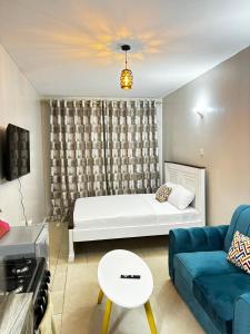 a living room with a white bed and a couch at Tsavo Coral Bells in Kiambu +7 photos
