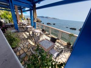 a balcony with tables and chairs and the ocean at Sunset View Apartments in Bar