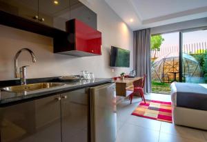 a kitchen with a sink and a counter with a table at The Ray Hotel and Studios in Beirut