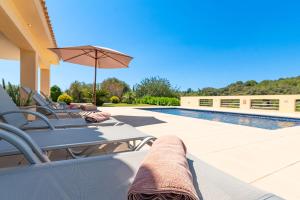 un patio con sillas y una sombrilla junto a la piscina en Villa Malagarba d'Enmig by Sealand Villas, en Pollensa 30 fotos más