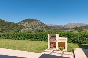 una silla sentada en el césped con montañas en el fondo en Villa Malagarba d'Enmig by Sealand Villas, en Pollensa