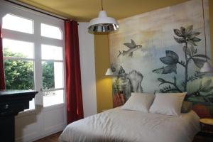 a bedroom with a bed and a painting on the wall at Maison Lucie, emplacement central, le tout à pied in Saint-Gilles-Croix-de-Vie