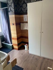 a bathroom with a white cabinet and a tub at Chambre année 70 in Brussels