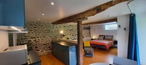 a bedroom with a bed and a stone wall at Les gîtes de La Petite Taupe - Studio Jo in Saint-Omer