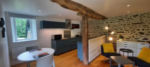a kitchen and living room with a table and chairs at Les gîtes de La Petite Taupe - Studio Jo in Saint-Omer
