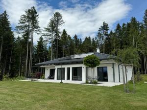 a small white house with a large yard at Ferienhaus Zörweg - Feels like home in Matzling