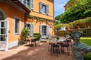 a statue in front of a building with tables and chairs at Hotel Vannucci in Città della Pieve