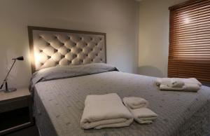 a bedroom with a bed with two towels on it at Manjimup Gateway Hotel in Manjimup