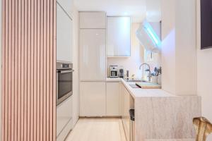 a kitchen with white cabinets and a counter at Little Bangkok - Luxury SPA Apartment in Toulon
