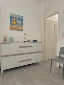 a living room with a dresser with a painting on the wall at La Perla a Marzamemi in Marzamemi +25 photos