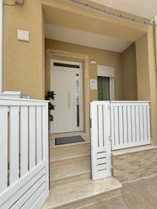 a house with a white fence and a door at La Perla a Marzamemi in Marzamemi