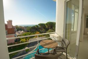 a balcony with a table and chairs and a view at Amazonia Estoril Hotel in Estoril