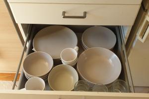 un tiroir rempli d'assiettes et de tasses dans une cuisine dans l'établissement A louer un appart dans une résidence calme, à Mont-Saint-Guibert 1 autre photo