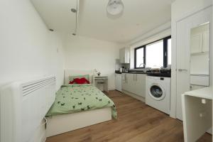 a white bedroom with a bed and a washing machine at Derwent Avenue self-contained apartments in Headington in Oxford