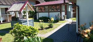 a garden with a gazebo and some flowers at Šturmų Sodyba in Ventė