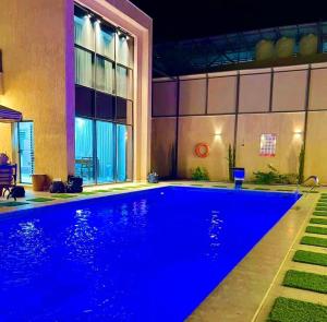 a swimming pool with blue lighting in a building at Aryam chalet in Al Khīrān