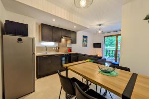 a kitchen and dining room with a wooden table at Superbe appartement au pied des pistes in La Féclaz