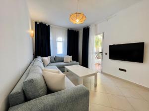 a living room with a couch and a tv at Blue Pearl Apartment in Cabo Negro