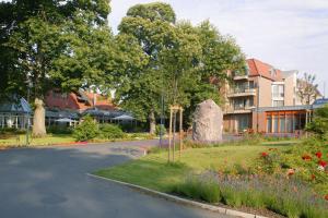 una strada in un parco con fiori e un edificio di Jammertal Resort a Datteln