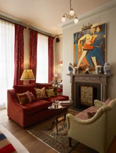 a living room with a red couch and a fireplace at The Zetter Marylebone in London