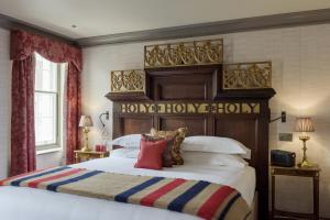 una camera con un grande letto con testiera in legno di The Zetter Marylebone a Londra
