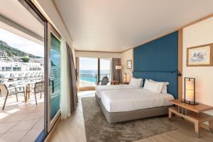 a hotel room with a bed and a balcony at Sesimbra Oceanfront Hotel - Preferred Hotels and Resorts in Sesimbra