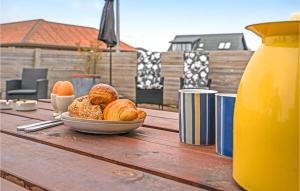 a table with a plate of bread and a jug of orange juice at Nice Apartment In Bindslev With Wifi in Bindslev