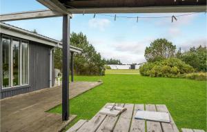 a backyard with a wooden deck and a lawn at 4 Bedroom Stunning Home In Thisted in Thisted