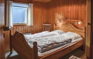 a bed in a wooden room with a window at 4 Bedroom Stunning Home In Thisted in Thisted