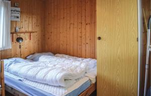 a bed in a room with a wooden wall at 4 Bedroom Stunning Home In Thisted in Thisted +3 photos