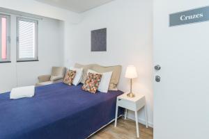 a bedroom with a blue bed with a chair and a table at Casa da Praça Double room - by Casas na Ilha in Funchal +7 photos