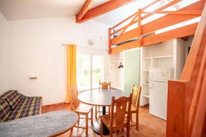 eine Küche und ein Esszimmer mit Tisch und Stühlen in der Unterkunft Village Vacances Le Lac Marin in Soustons