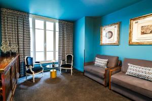 a living room with blue walls and a couch and chairs at Hotel Villa Nicolo - Tour Eiffel in Paris