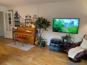 a living room with a piano and a flat screen tv at Spacious 3 Bedroom next to Thon Hotel, Storsenter Shopping, and 15 minutes to Oslo in Sandvika