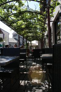 puste patio ze stołami, krzesłami i drzewami w obiekcie Hotel Restaurant Cousseau w mieście Parentis-en-Born