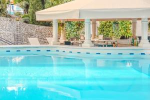 a pool with chairs and a gazebo at Lago Garden Apart-Suites & Spa Hotel in Cala Ratjada