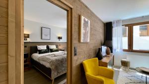 ein Schlafzimmer mit einem Bett und einem gelben Stuhl in der Unterkunft Homency - Résidence Fermes de l'Alpe A003 in L'Alpe-d'Huez + 12 Fotos