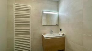 ein Badezimmer mit Waschbecken und Spiegel in der Unterkunft Homency - Résidence Fermes de l'Alpe A003 in L'Alpe-d'Huez