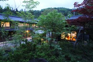 a view of a garden in front of a building at Minshuku Takizawa in Takayama