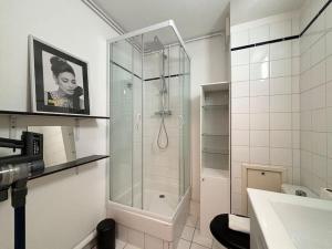 W łazience znajduje się szklana kabina prysznicowa i umywalka. w obiekcie Appartement en hyper-centre de Lille w Lille