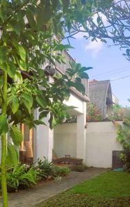 a white building with a bench in a yard at Villa Kenken - 2 Bedrooms villa close to Keramas Surfing Beach in Keramas