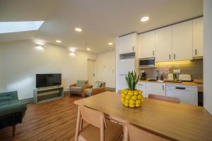 cocina y sala de estar con mesa y un bol de fruta en Azimute 5, en Angra do Heroísmo