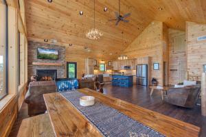 a large living room with a table and a fireplace at Southern Stars by Stony Brook Cabins in Rocky Grove