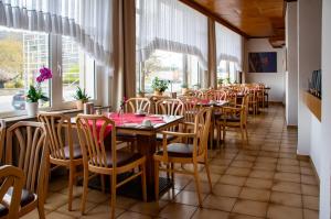 a dining room with tables and chairs and windows at Hotel zum Anker in Andernach