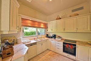 a kitchen with white cabinets and a window at Villa Domus Riviera in Athens +54 photos